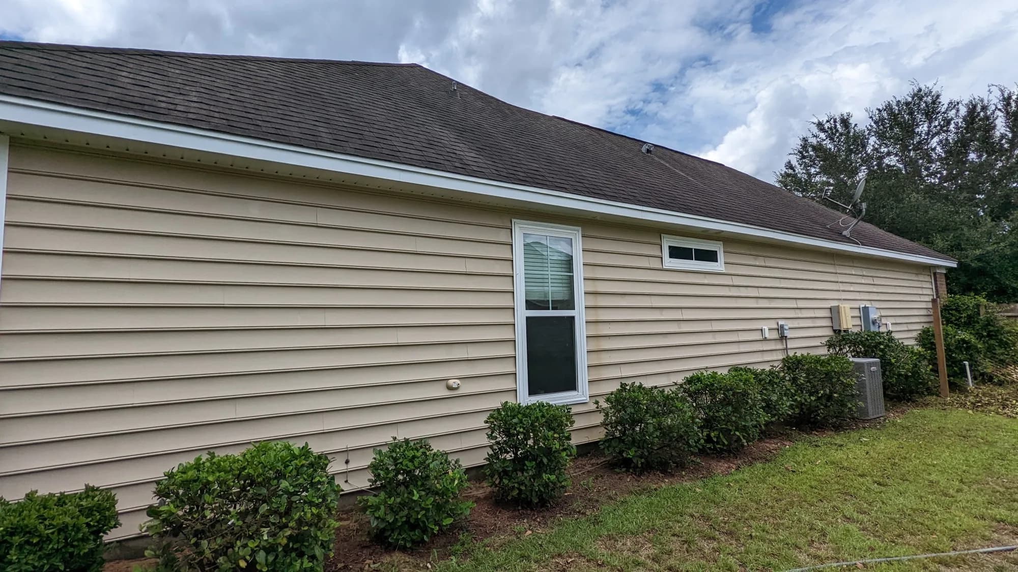 The same beige vinyl siding bright and clean after a soft wash