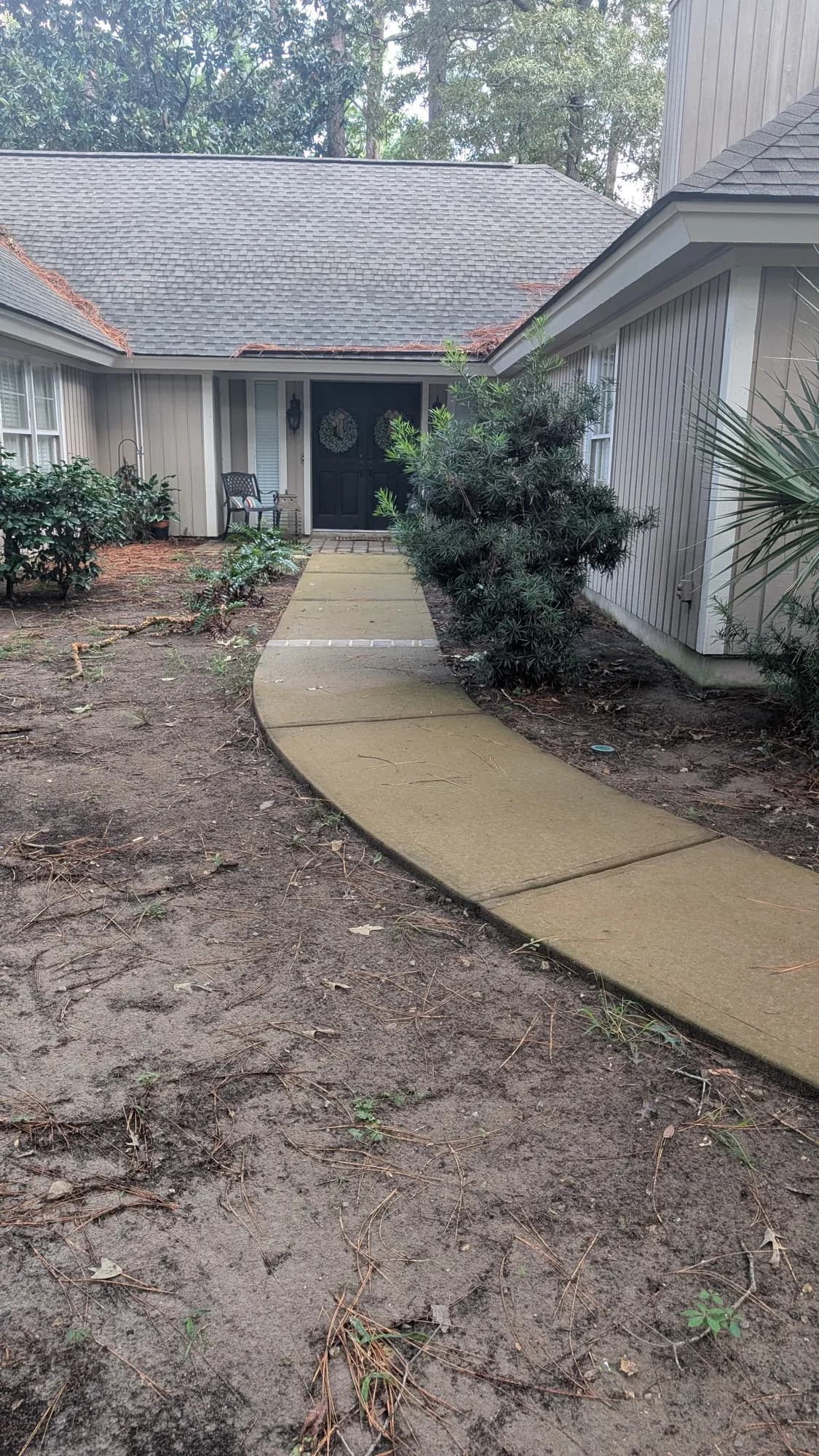 Curved front concrete walkway dull and stained before cleaning